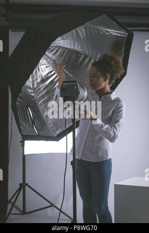 Fotografo femmina regolazione fari stroboscopici Foto Stock