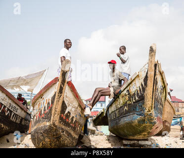 Pescatore su barche da pesca tradizionali, Accra, Ghana Foto Stock