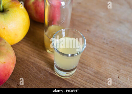 La difesa immunitaria boosting, pelle chiarire, apple disintossicante di aceto di sidro sul tavolo di legno con mele mature come decorazione Foto Stock
