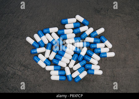 Droga pillole capsule overhead su sfondo scuro Foto Stock