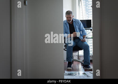 L uomo un caffè mentre si lavora a casa Foto Stock