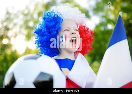 Funny bambina il supporto e il tifo la sua nazionale di calcio durante il campionato di calcio Foto Stock