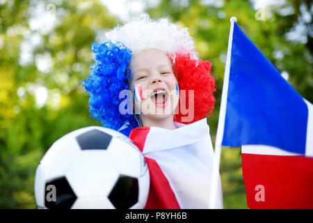 Funny bambina il supporto e il tifo la sua nazionale di calcio durante il campionato di calcio Foto Stock