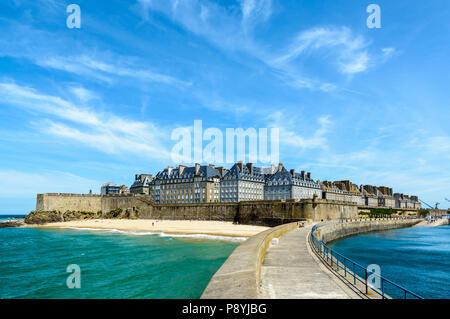 La città fortificata di Saint Malo, Francia, con granito di edifici residenziali che sporge al di sopra del terrapieno e la Mole spiaggia ai piedi della parete. Foto Stock