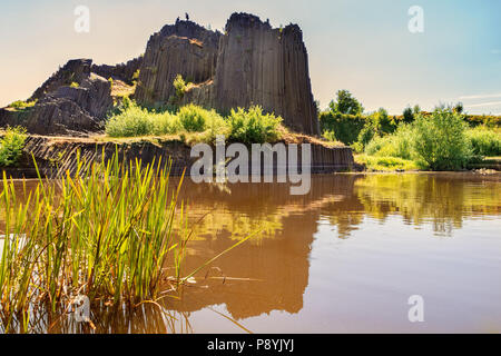Roccia di basalto con la riflessione sulle acque del lago. Famoso paesaggio landmark chiamato Panska skala a Kamenicky Senov a nord della Repubblica ceca, 150 km nort Foto Stock
