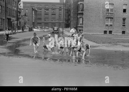 Bambini il raffreddamento in acqua dall'idrante di fuoco, Chicago, Illinois, USA, John Vachon, Farm Security Administration, Luglio 1941 Foto Stock