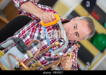 Plumber segare un tubo flessibile Foto Stock