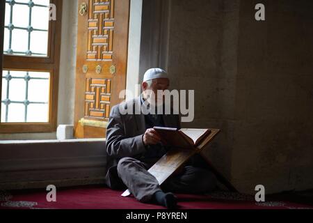 Il vecchio uomo che legge il Corano nella moschea Turchia Foto Stock