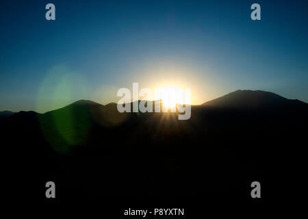 Lens Flare lungo con il tramonto su UAT montagna del Sangre de Cristo la gamma della montagna di Taos New Mexico Foto Stock