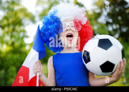 Funny bambina il supporto e il tifo la sua nazionale di calcio durante il campionato di calcio Foto Stock