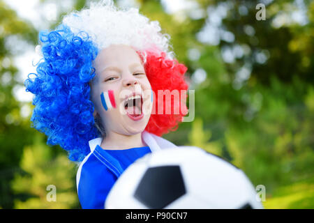 Funny bambina il supporto e il tifo la sua nazionale di calcio durante il campionato di calcio Foto Stock