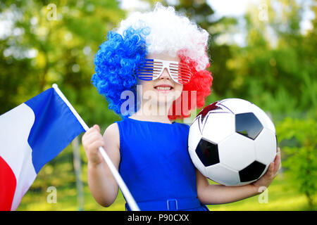 Funny bambina il supporto e il tifo la sua nazionale di calcio durante il campionato di calcio Foto Stock