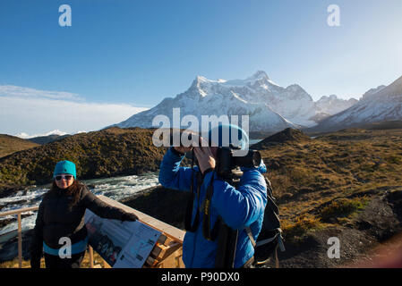 I turisti in piedi sulla piattaforma di visualizzazione vicino a. il Salto Grande Cascata con Paine Grande Montagna in background. Foto Stock