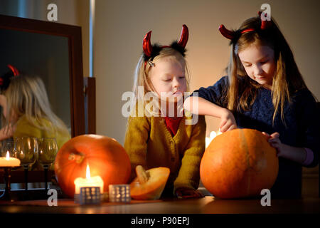 Due sorelle felici su Halloween. Bambini divertenti in costumi di carnevale  seduti sul tetto. Bambini allegri con zucca, bacchetta magica e libro di  incantesimi Foto stock - Alamy