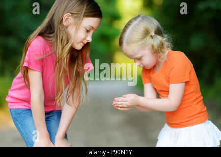 Due adorabili poco ragazza cattura babyfrogs nella foresta di estate Foto Stock