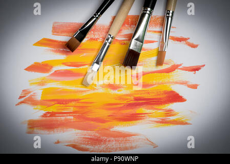 I tratti di pennello e una spatola pittura ad olio i colori rosso e giallo su sfondo bianco Foto Stock