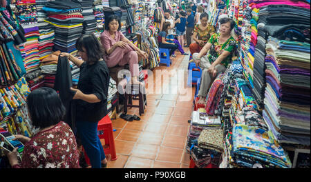 Vietnamita stallholders femmina la vendita di tessuti e prodotti tessili al Tan Dinh mercati nella città di Ho Chi Minh, Vietnam. Foto Stock