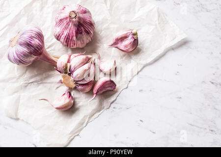 4 spicchi di aglio e le lampadine su marmo bianco bordo. Foto Stock
