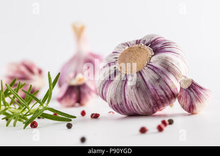 4 spicchi di aglio e le lampadine con rosmarino e pepe isolato su bianco. Foto Stock