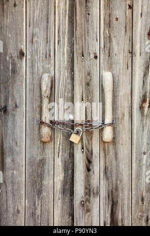 Vecchia porta di legno bloccato con rusty catena e lucchetto Foto Stock
