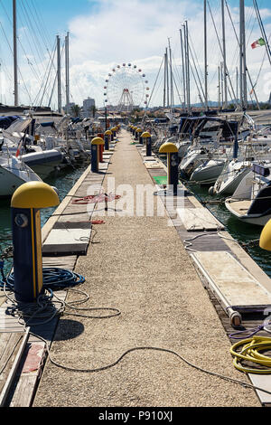 Barche ormeggiate nel porto turistico di Pescara e la ruota panoramica Ferris sfondo Foto Stock