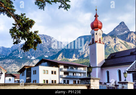 Chiesa parrocchiale di Maria Heimsuchung con le montagne sullo sfondo - Ehrwald, Tirolo, Alpi austriache Foto Stock