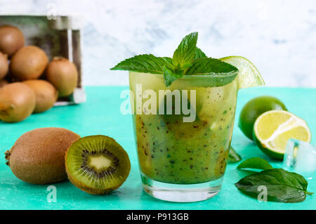 La vitamina a bere con kiwi, menta, calce, carbonato di sodio in un vetro su uno sfondo luminoso. Estate una bevanda rinfrescante. Foto Stock