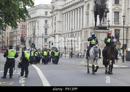 La polizia e i cavalli della polizia in pieno le attrezzature antisommossa per le strade di Londra Foto Stock