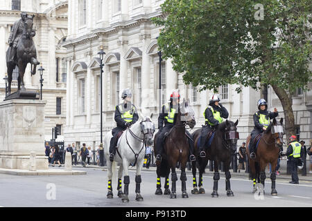 La polizia e i cavalli della polizia in pieno le attrezzature antisommossa per le strade di Londra Foto Stock