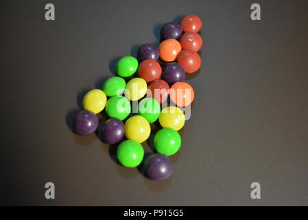 Dolci deliziosi, scuotere le caramelle viola, giallo, rosso, arancione e verde chiaro su sfondo opaco. Foto Stock