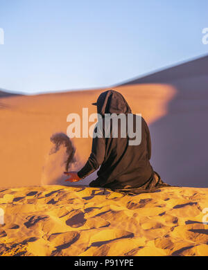 L'uomo gioca con la sabbia in aria nel deserto Foto Stock