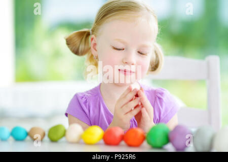 Carino bambina divertendosi con colorati di creta per modellare in un asilo nido. Creative kid lo stampaggio a casa. Il bambino gioca con la plastilina o la pasta. Foto Stock