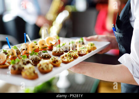 Cameriere che trasportano le piastre con piatto di carne su qualche evento festivo, un party o un ricevimento di nozze Foto Stock