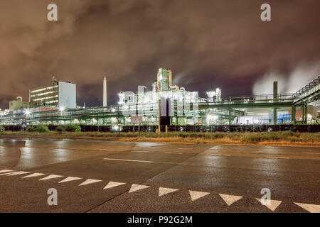 Illuminata produzione petrolchimica impianto contro un nuvoloso cielo blu di notte, Anversa, Belgio. Foto Stock