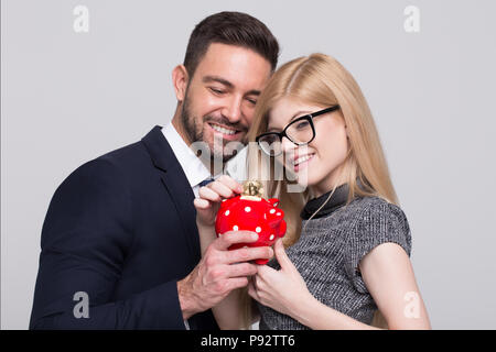 Giovani smart giovane goccia bitcoin nel salvadanaio Foto Stock
