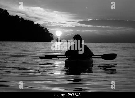 Kayakers godere di un tramonto tropicale a nord mare delle Andamane al largo della costa di Ko Surin Nuea isola in Mu Ko Surin National Park, Thailandia Foto Stock