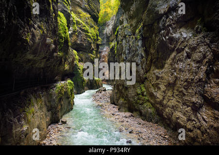 Blu dell'acqua che scorre nella gola di Partnach o Partnachklamm, incise da un torrente di montagna nella valle Reintal vicino al sud della città tedesca di Garmisch-P Foto Stock