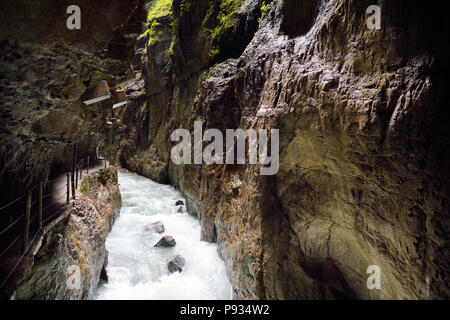 Blu dell'acqua che scorre nella gola di Partnach o Partnachklamm, incise da un torrente di montagna nella valle Reintal vicino al sud della città tedesca di Garmisch-P Foto Stock