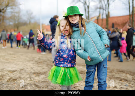 Due graziosi bambine Indossando cappellini verdi e accessori per celebrare la festa di San Patrizio a Vilnius. Bambini divertirsi al tradizionale Festival irlandese. Foto Stock