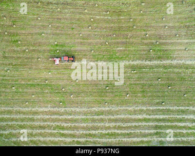 Vista aerea di un trattore rendendo i cubetti di fieno visto direttamente al di sopra. Copia dello spazio per il tuo testo disponibile. Foto Stock