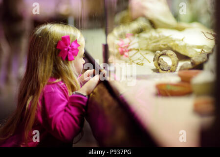 Carino bambina guardando gli animali negli zoo. Bambino guardando animali da zoo attraverso la finestra. I serpenti in un terrario. Foto Stock