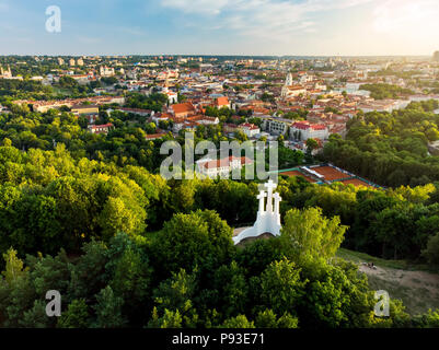 Vista aerea del Tre Croci monumento prospiciente la città vecchia di Vilnius sul tramonto. Vilnius paesaggio dalla collina delle Tre Croci, situato in Kalnai Foto Stock