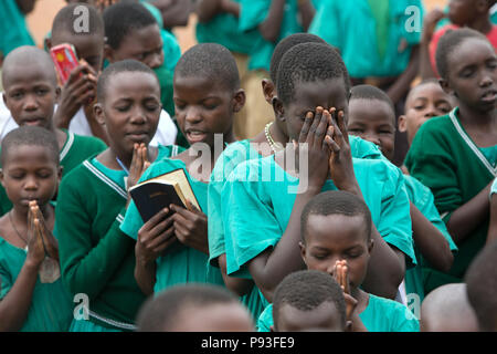 Bombo, Uganda - pregare gli studenti a scuola appello nella schoolyard di San Giuseppe Bombo misti scuola primaria. Foto Stock