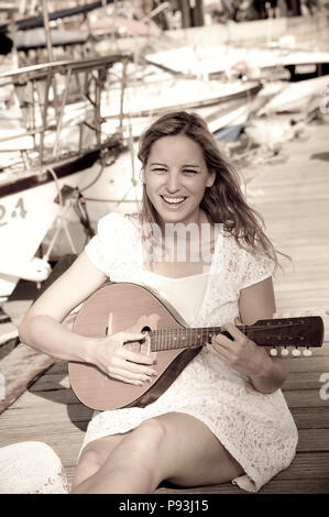 La bionda signora suonare la chitarra Foto Stock