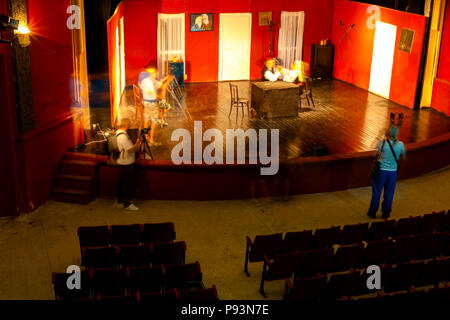 Una lunga esposizione foto, i fotografi stanno prendendo foto insieme di giovane donna in posa di teatro vuoto stadio. Foto Stock