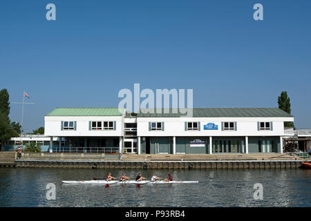 I rematori di prendere parte alla regata di Kingston, sul fiume Tamigi a Kingston, Surrey, Inghilterra, passare un edificio sull isola di Raven's ait Foto Stock