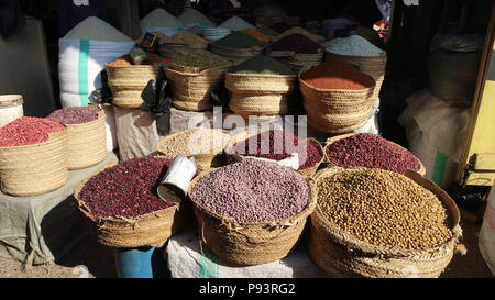 Stalla di mercato con cesti tessuti pieni di impulsi diversi, Arusha, Tanzania, Africa. Foto Stock