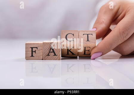 Imprenditrice di sostituzione a mano in legno blocchi cubici da fingere di fatto parola Foto Stock