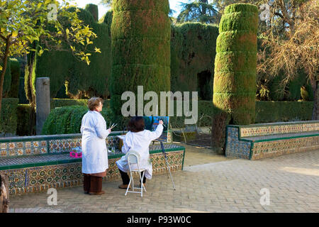 Gli artisti della pittura al di fuori del Cenador de Carlos V nel Jardín del Cenador de la Alcoba, Real Alcázar giardini, Sevilla, Andalusia, Spagna Foto Stock