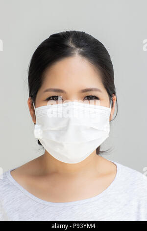 Donna asiatica che indossa la maschera per il viso per la protezione Foto Stock